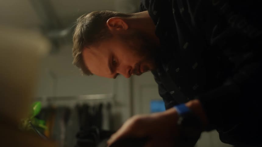 A man is checking a piece of fabric