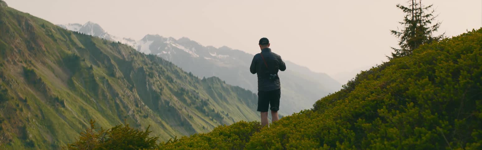 A man is photographing the green mountains