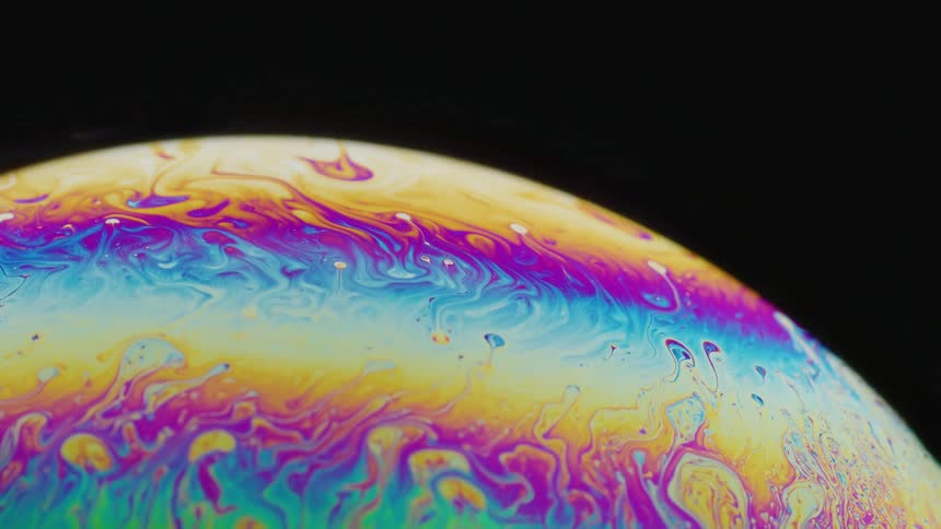 Fluorescent colors move on the surface of a sphere as it drips and blends in an organic manner