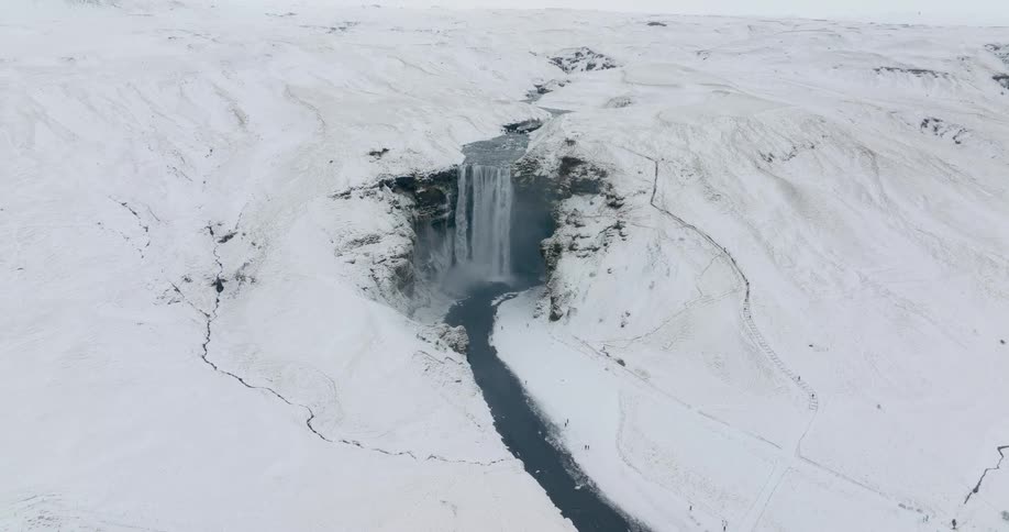 A waterfall is in the middle of the snow