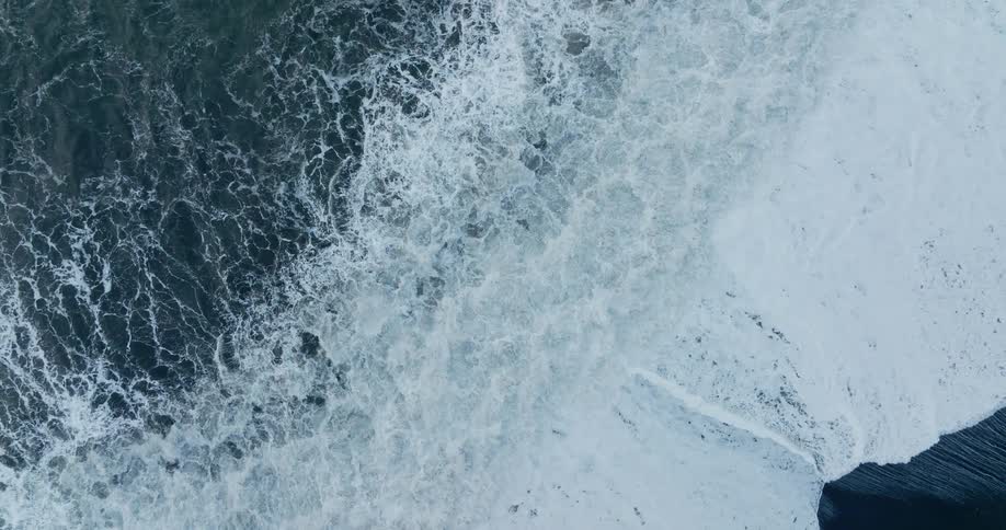 Top down aerial view of sea waves crashing on a coast