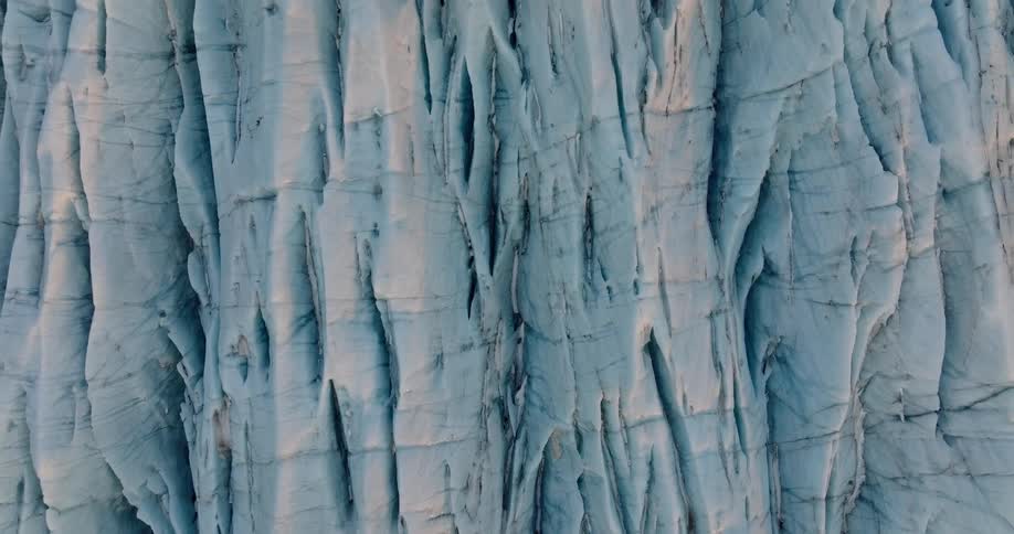 Lines cross across ridges and crevices of blue tinted glacier