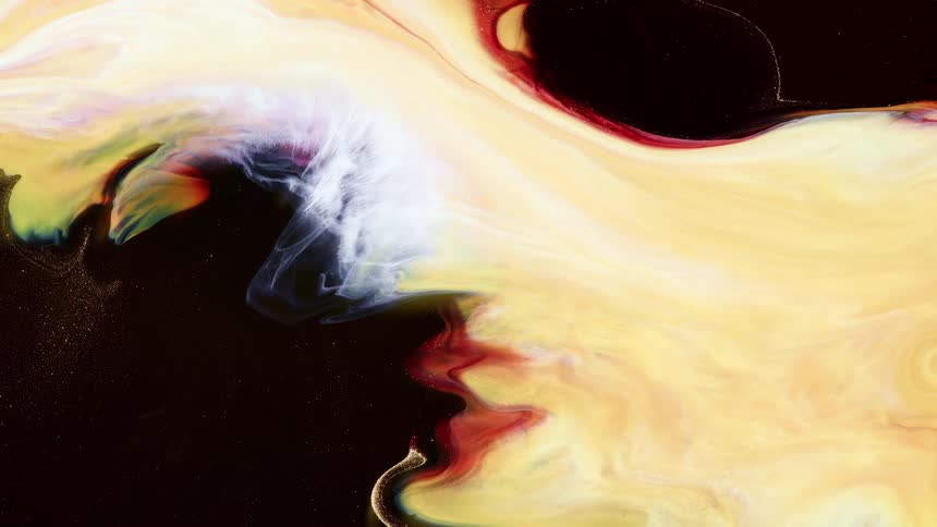 A dark liquid has a mass of yellow and orange liquid dispersing throughout it such that it resembles cosmic gasses expanding