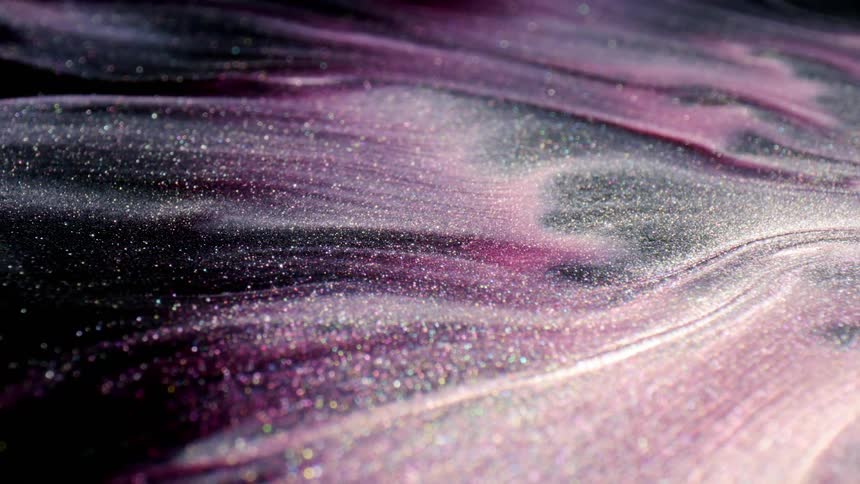 A dark liquid with a purple hue and a glitter texture flows and mixes together
