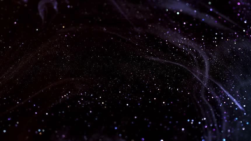 A darkened space is filled with a cloud of glittering particles that shimmer with blues and purples