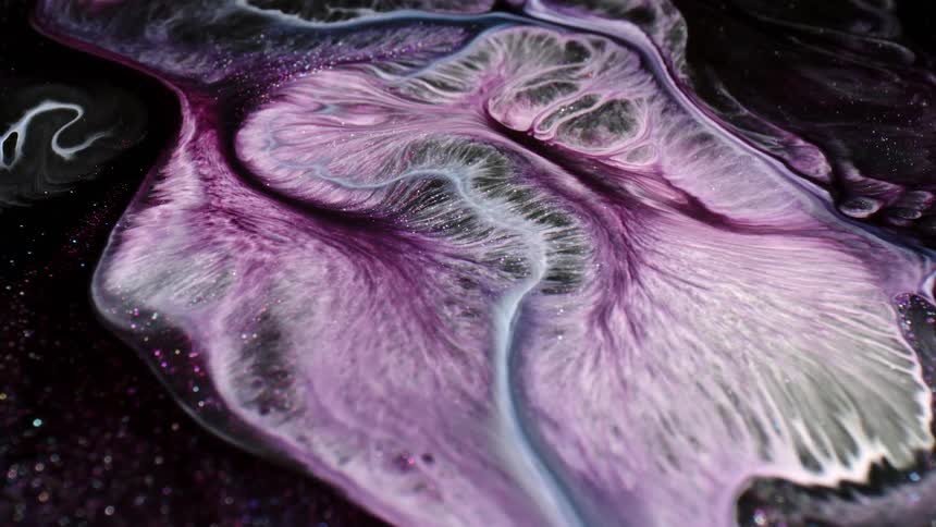 A purple and white liquid slowly spreading out