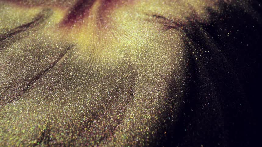 Sparkling flowing material forms mounds