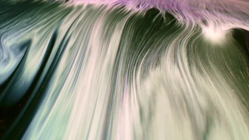 A dark fluid is mixed with a whitish fluid and the current of the two fluids can be seen as they flow together