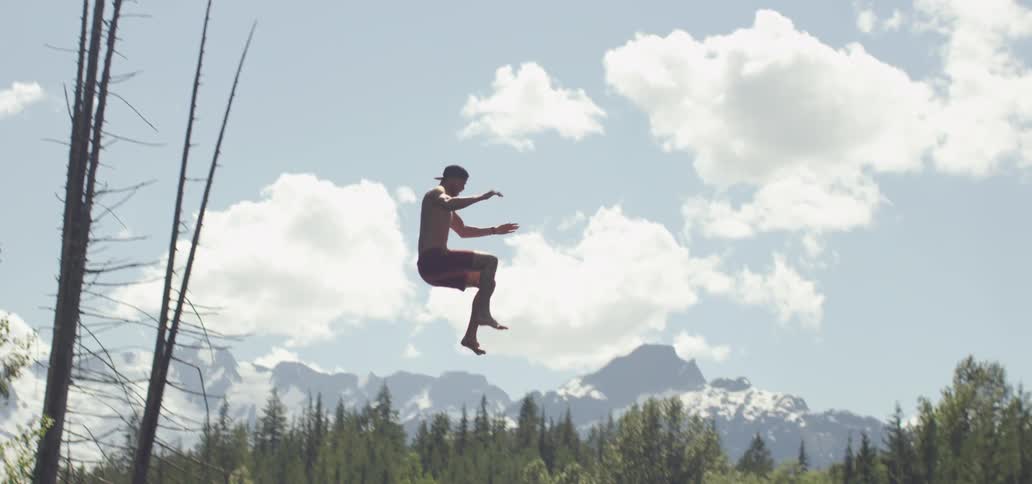 Person letting go  of a rope and splashing into the water for below