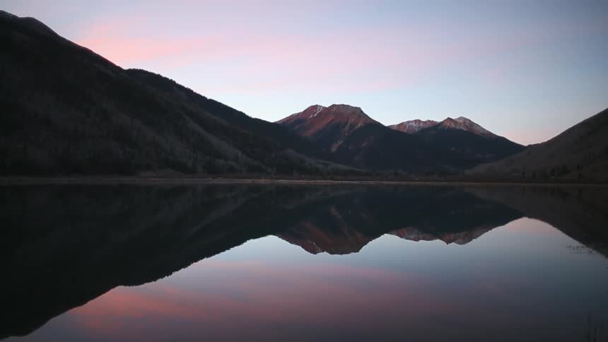 A lake is calm before mountains