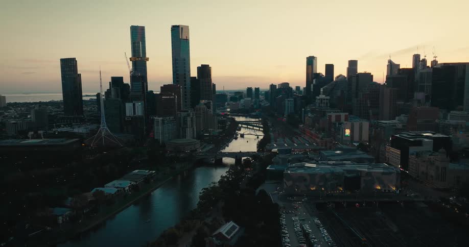 An aerial view of a river running through a city with tall office buildings