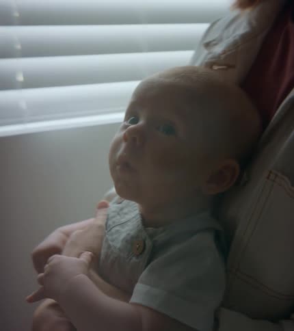 Infant sitting in mothers lap