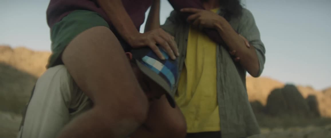 A group of friends laugh while giving piggyback rides in a canyon