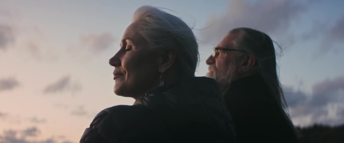 Man and woman sitting outside looking sentimentally in the distance