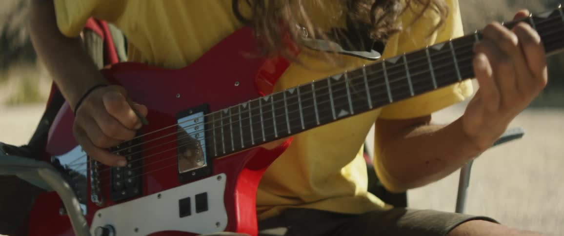 A man is playing guitar outside