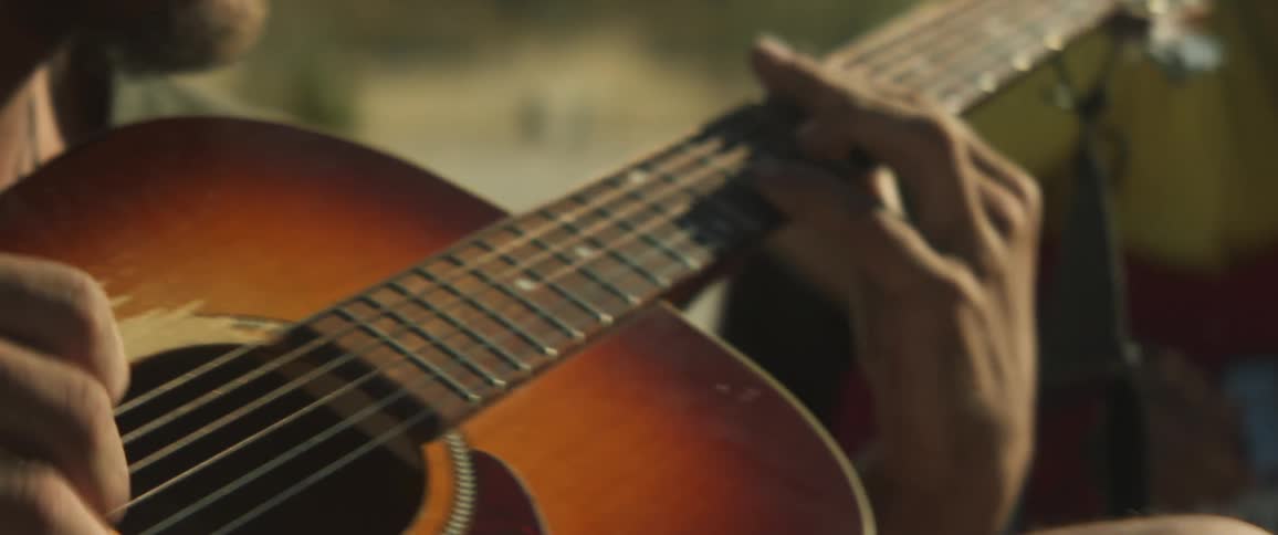 An up close of a guitar a man is playing