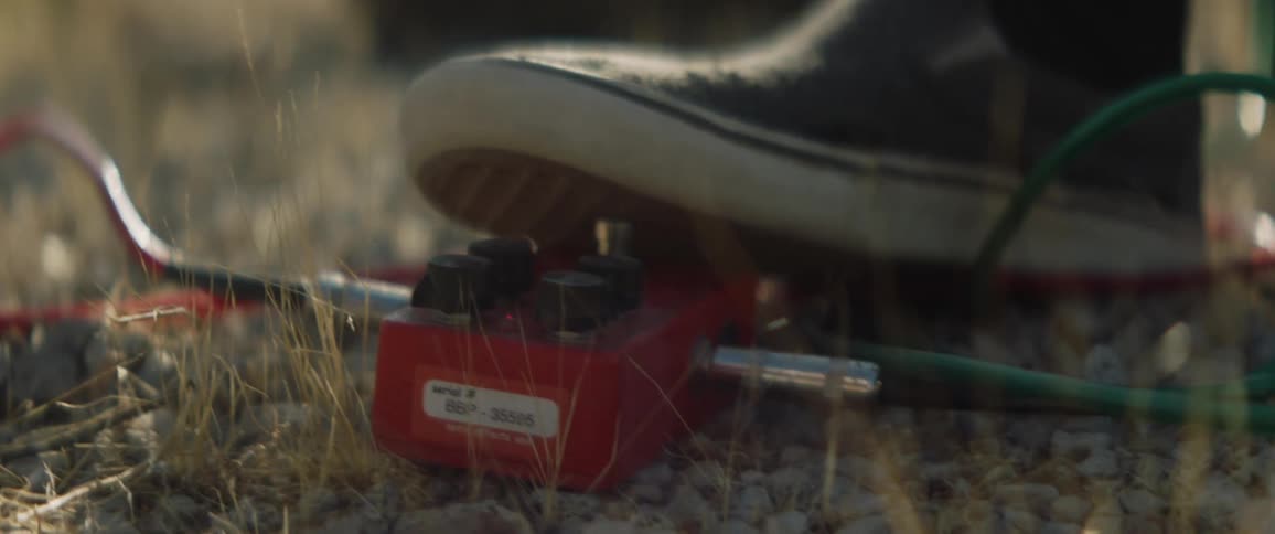 A person pushes a button on the ground with their foot