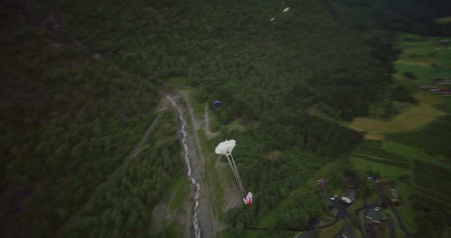 A para glider releasing their parachute as they come down