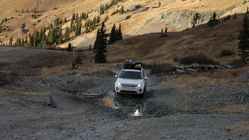 A vehicle is driving over rough terrain
