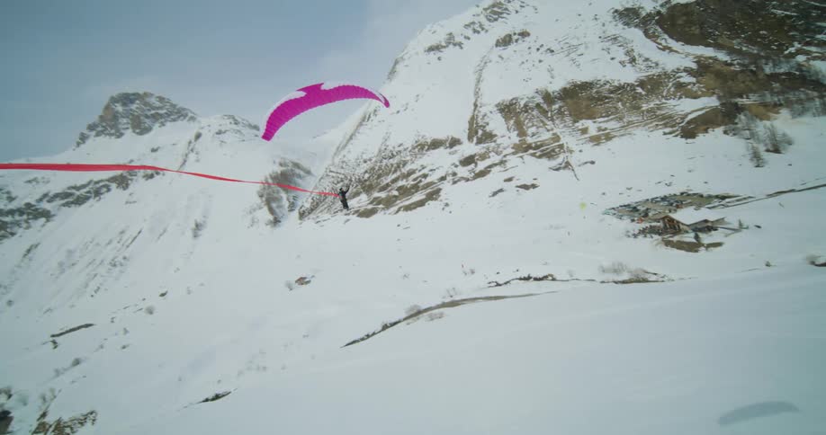 Paraglider skier preps for a drop