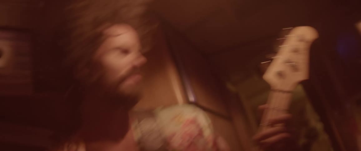 A man is playing the guitar and jumping around