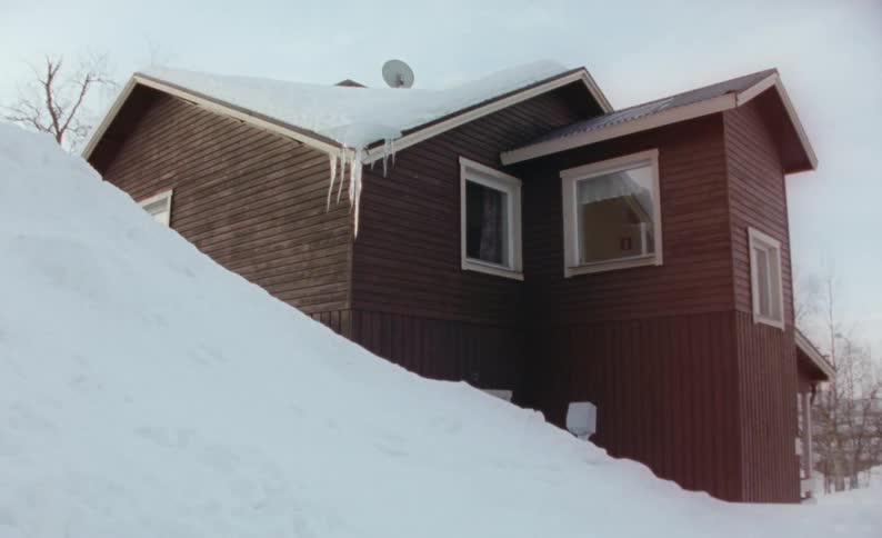 The cabin is surrounded by snow