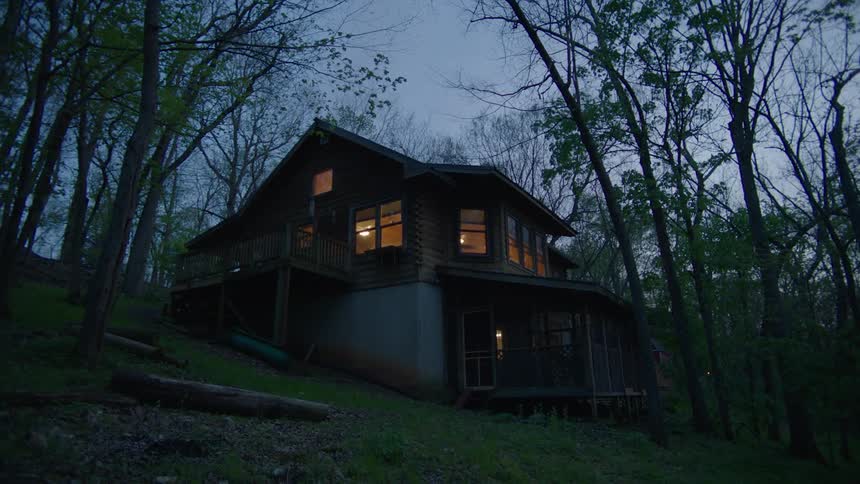 The view is of a cabin that is located in the woods