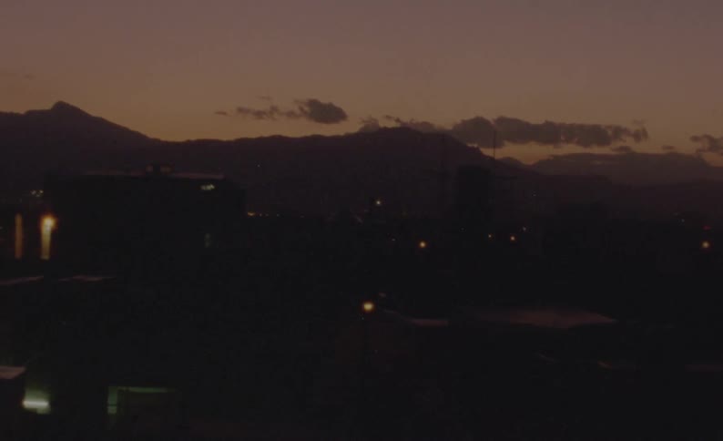 A silhouetted mountain in the distance at dusk