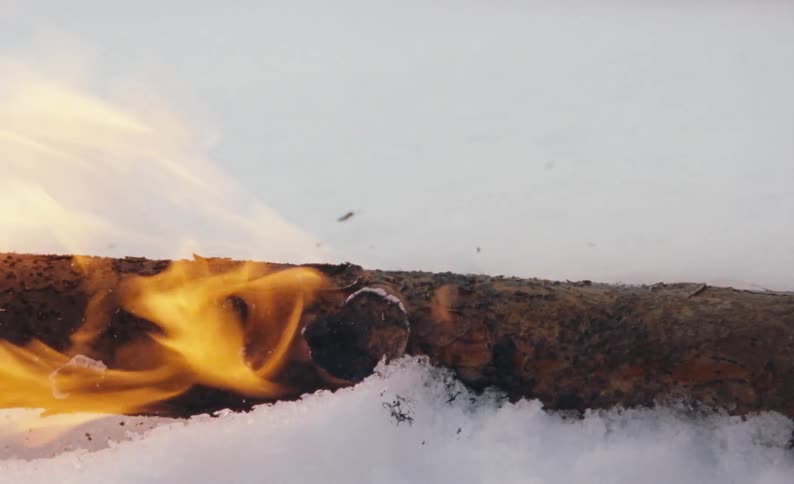 The burning log is melting the snow