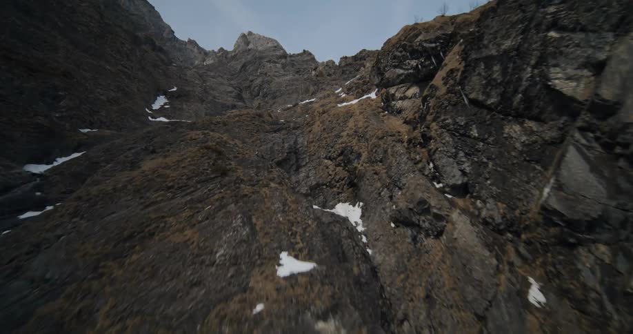 A mountain region and valley with bare trees and snow