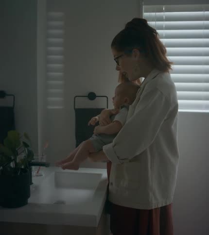 Woman playing with her baby in front of a mirror