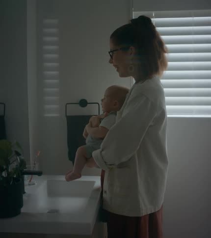 Young mother is holding there baby in the bathroom