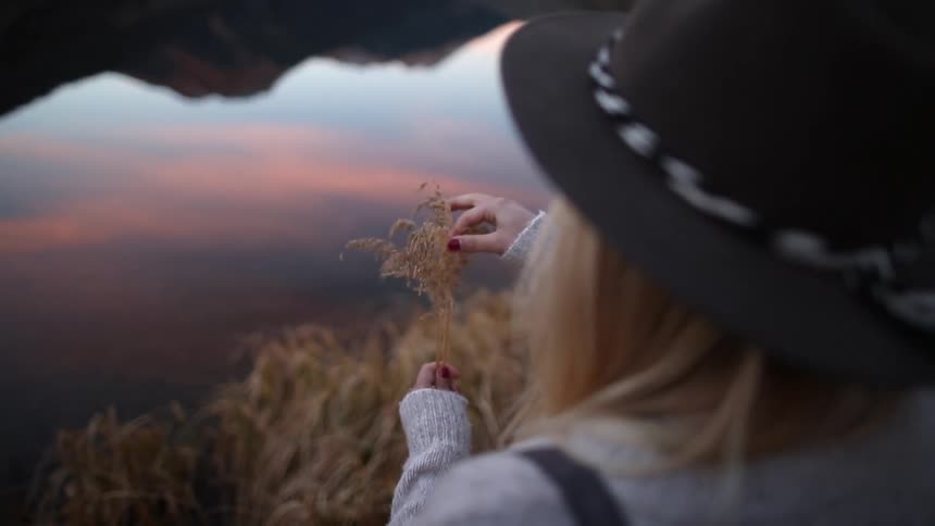 A woman adjusts amber colored stalks