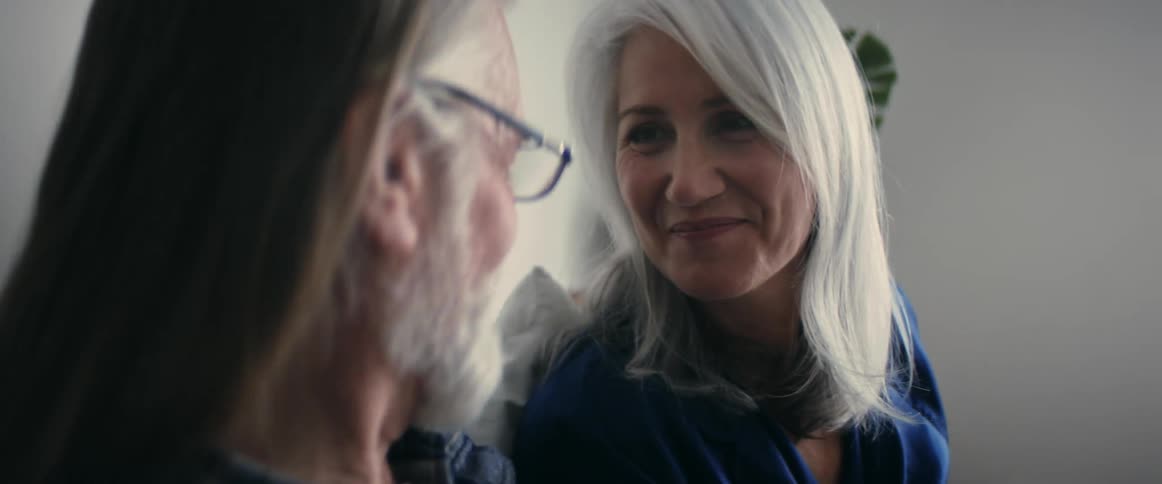 A grandmother and grandfather smiling and kissing
