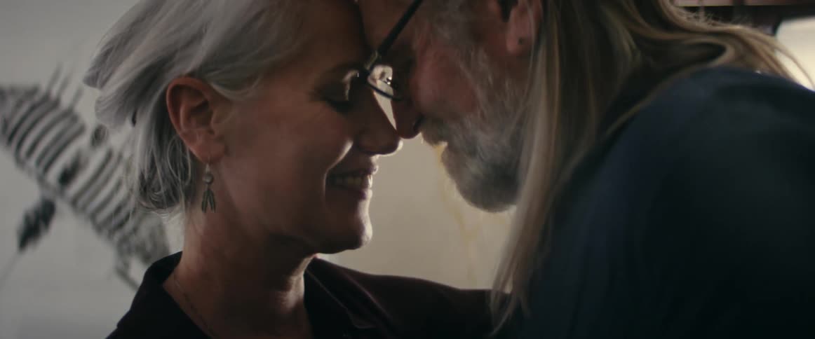 Older couple smile and touch foreheads while slow dancing