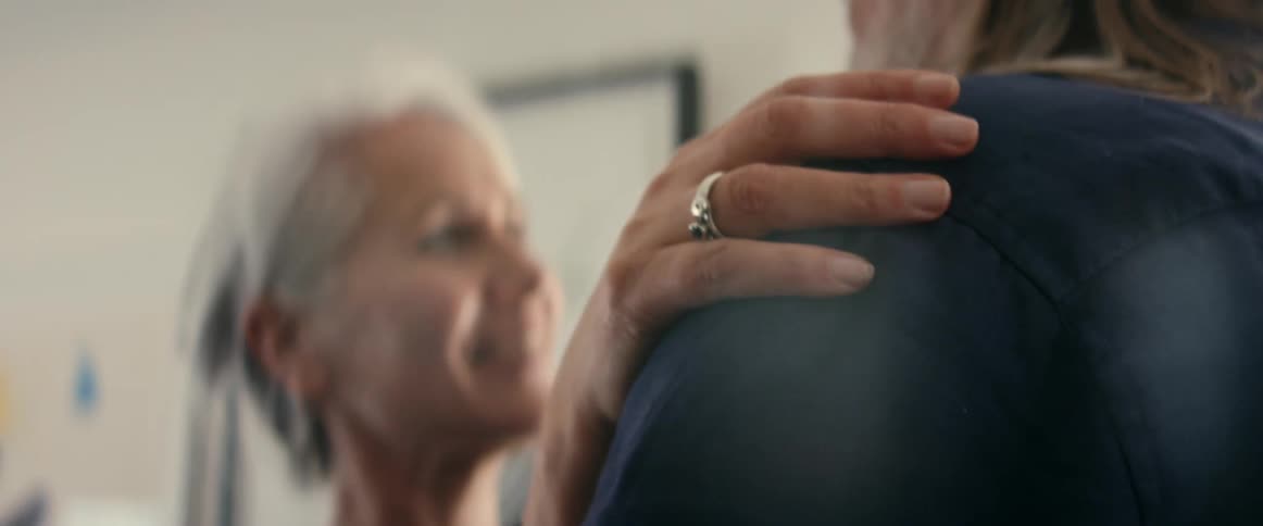 Woman dances with her hand on mans shoulder in home