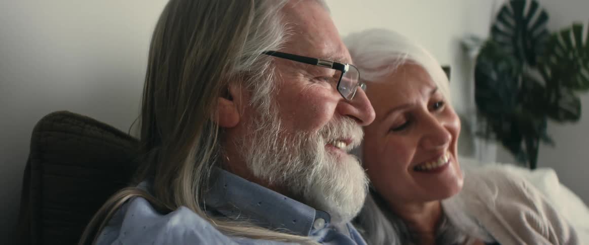 Elderly woman and man make video call on smartphone in room