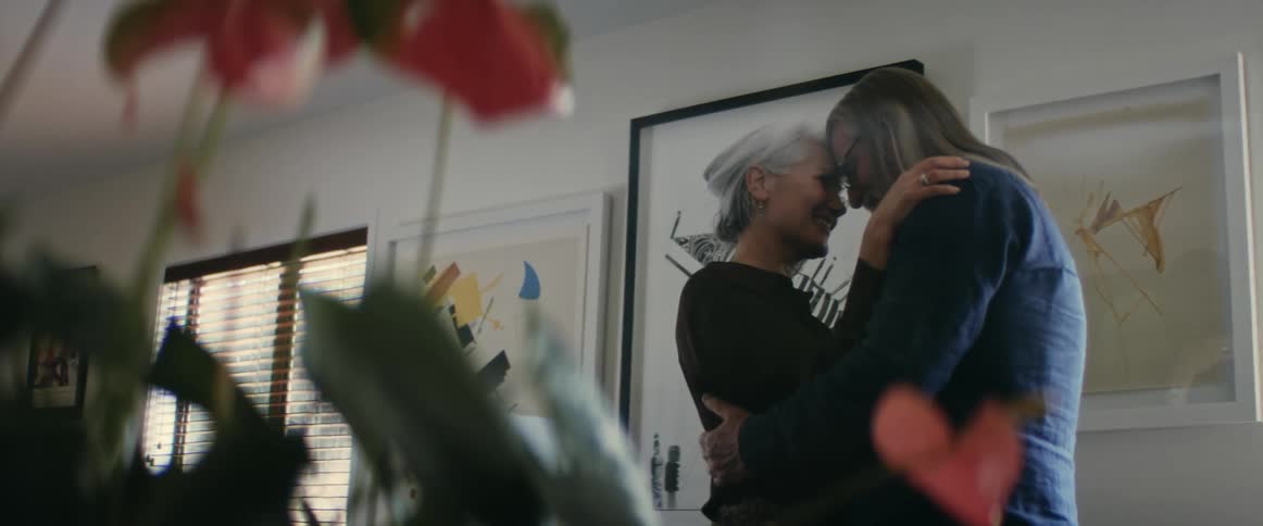 The view is of an elderly couple that is dancing inside