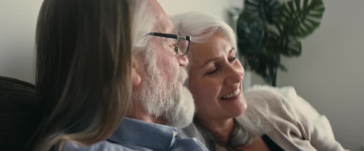 An older couple is sitting down inside of there home