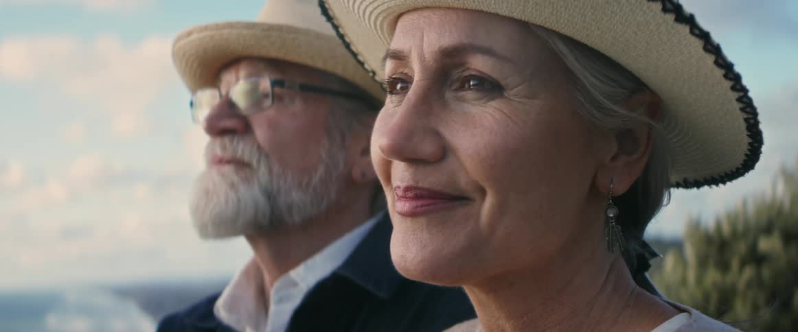 Close up of older couple admiring view from atop of a mountain