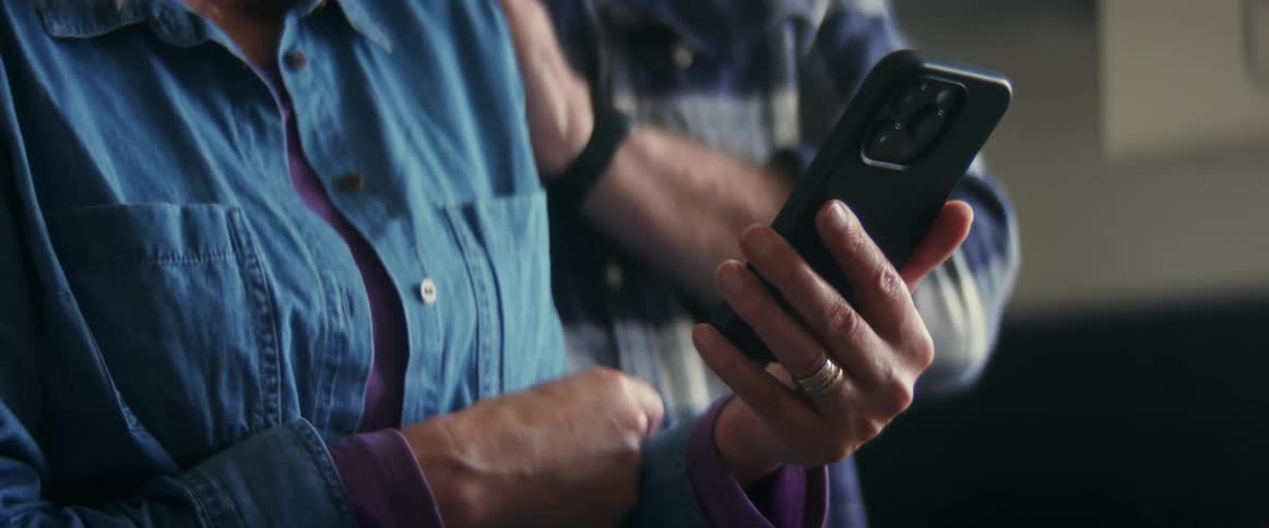 Two people are looking at a cellphone together
