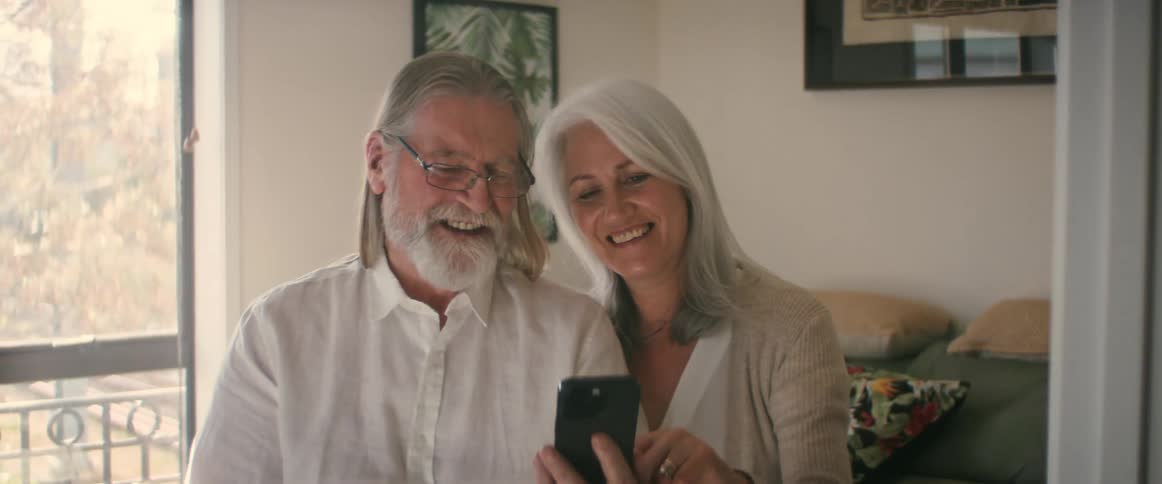 Couple works with each to laugh on the phone