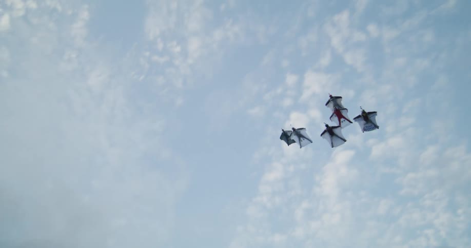 A group of people flying in parachute suits