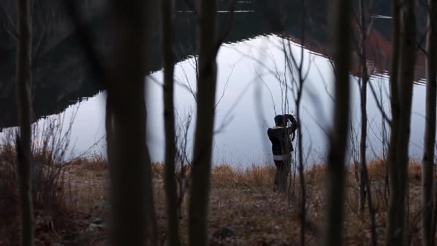 A man is photographing by a lake