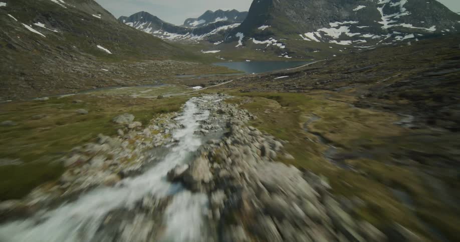 An aerial of water running down a hill along a mountainside slope