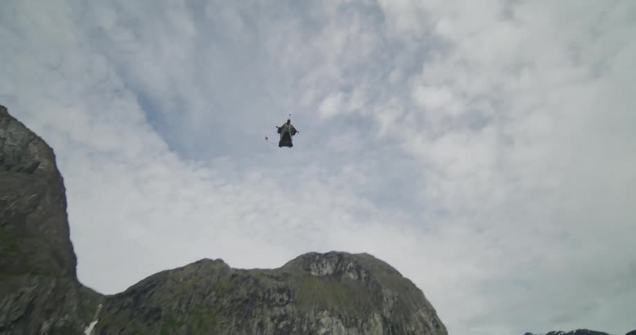 Someone is going out of a parachute in the middle of the nature area