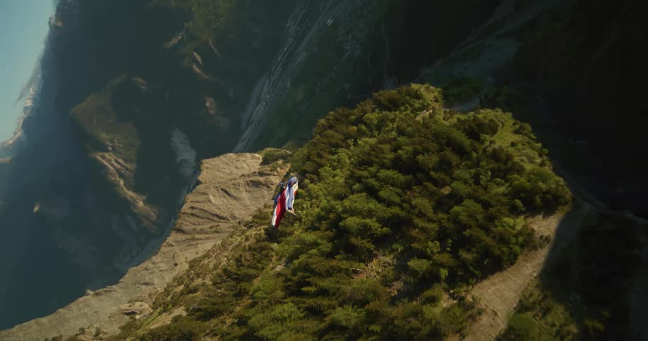 Person flies over forest mountains and misty valley