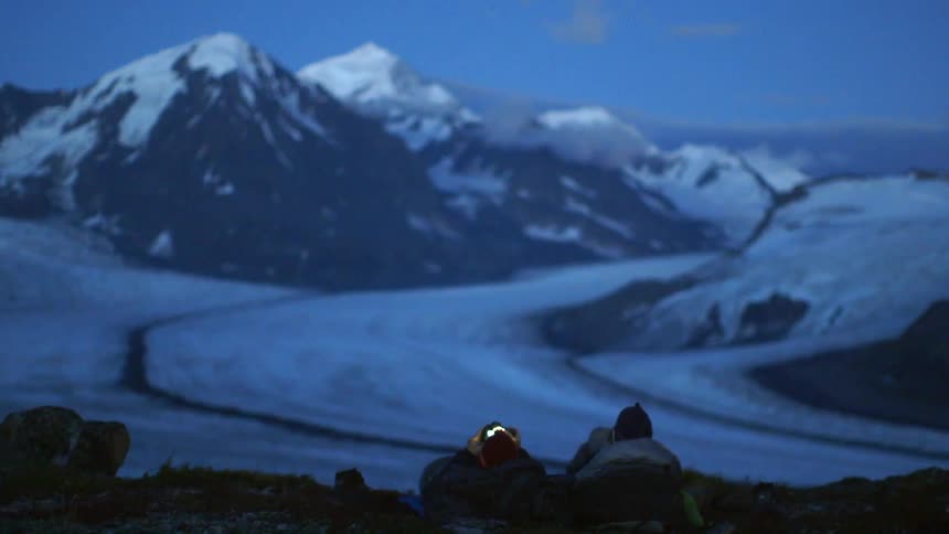Person sitting in a snowy wilderness at sunset