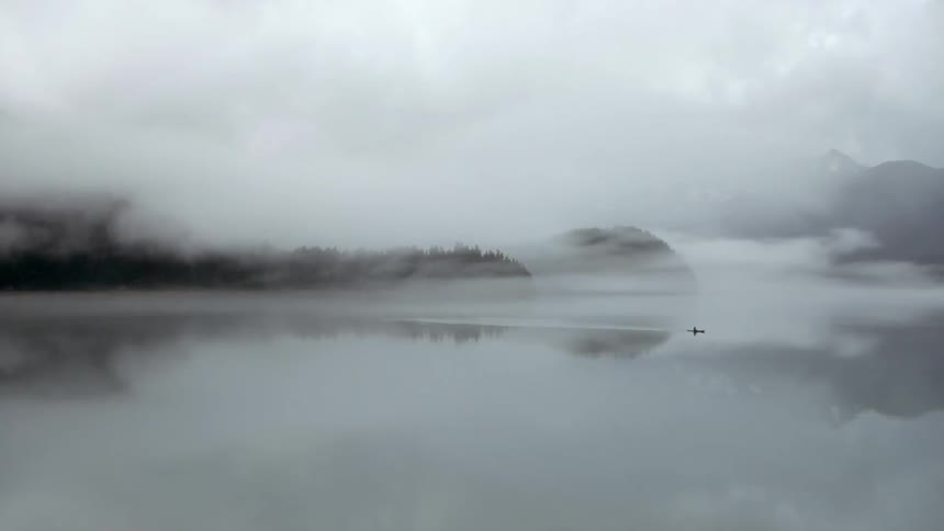 Kayaker covered with heavy fog at sea side