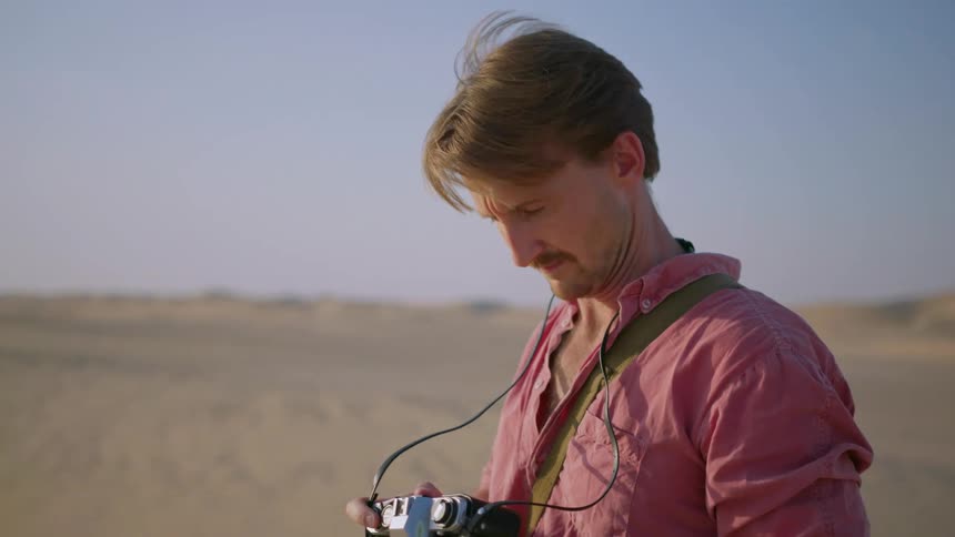 A photographer takes a picture in a desert